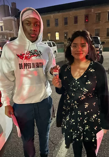 two people holding a voted sticker